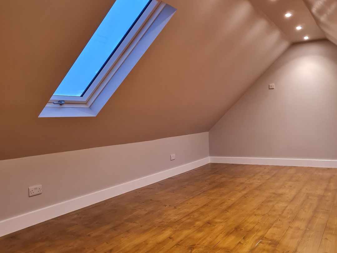 A roof window and downlights along the sloping ceiling