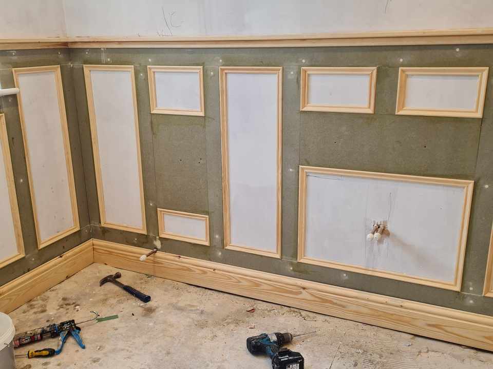 Wall panelling being fitted, with the tools still on the floor