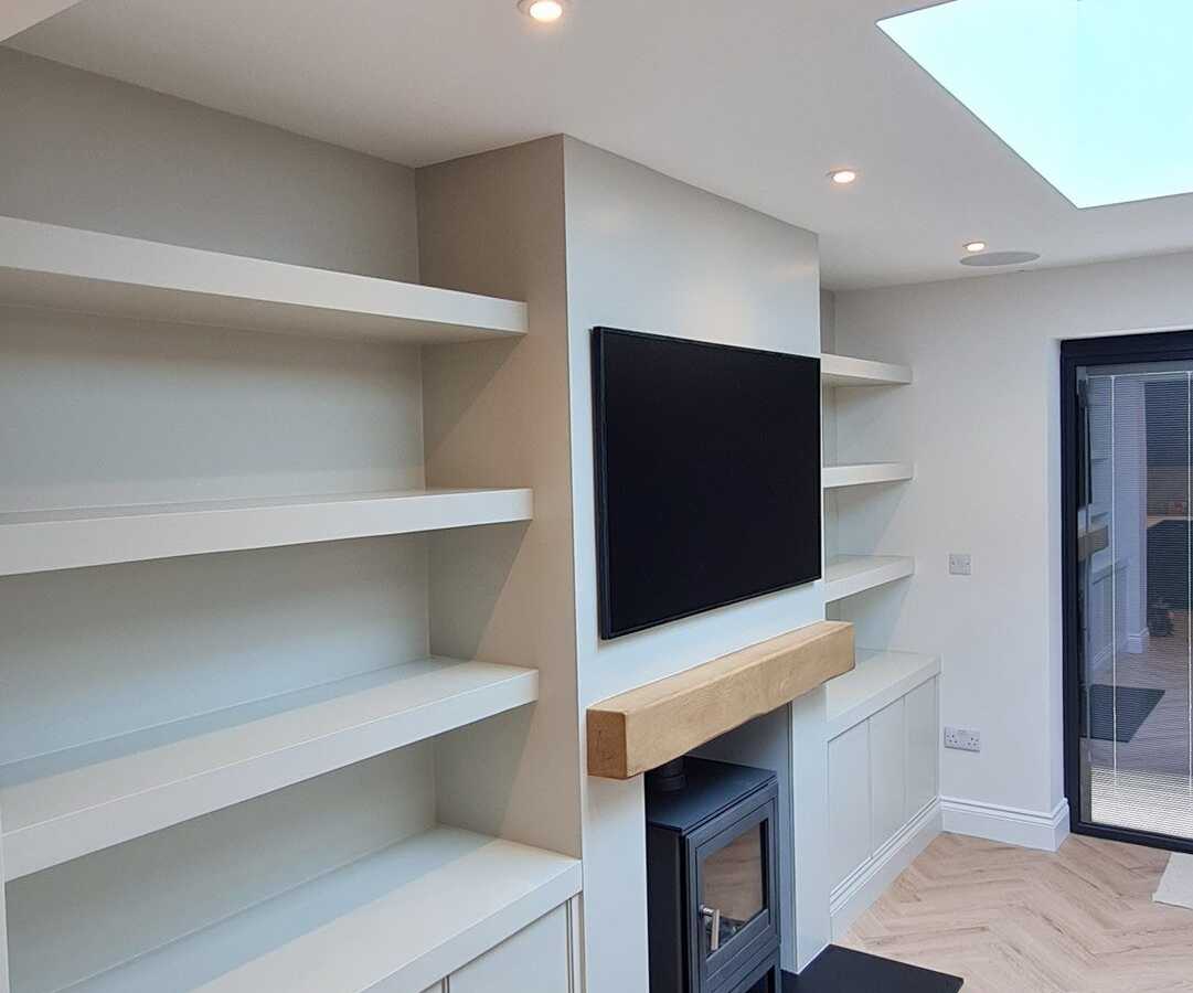 Alcove shelving and cupboards either side of a wood burner