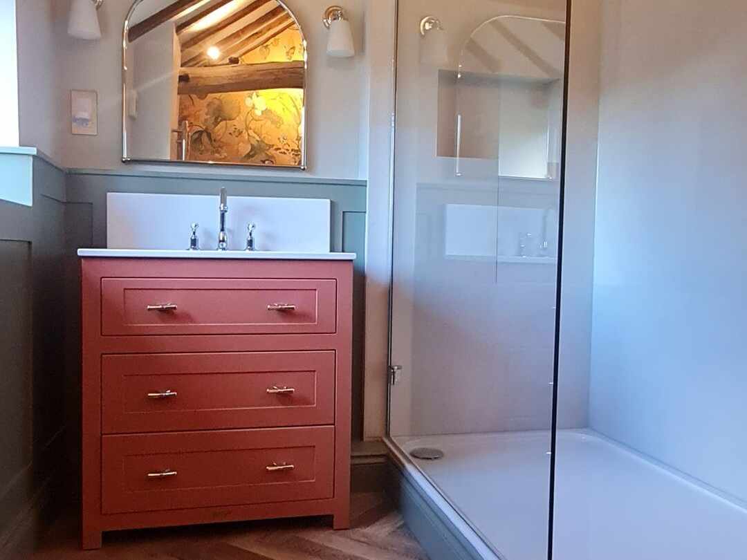 The en-suite: a red painted vanity unit and a walk-in shower