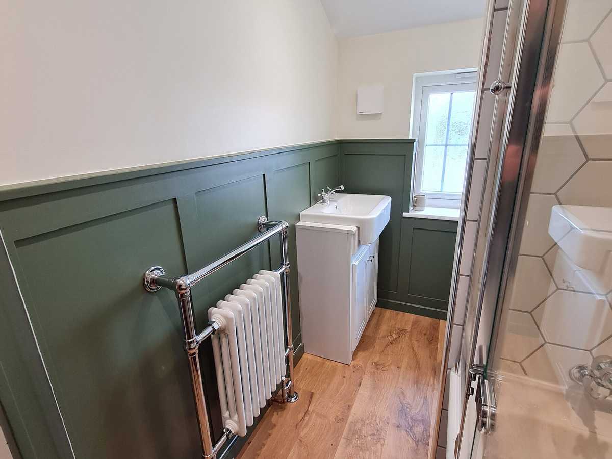 A traditional column radiator against green panelling